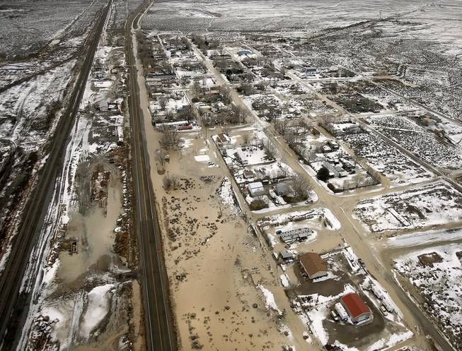 An aerial view of a flooded area with a red house in the middle