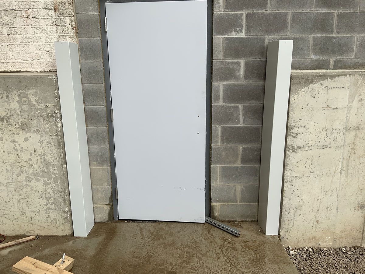 A white door with a brick wall behind it