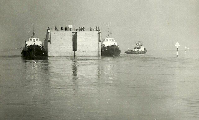 A black and white photo of a group of boats in the water.