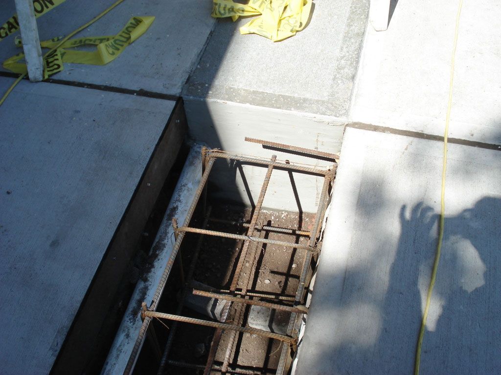 A yellow caution tape is laying on a concrete surface