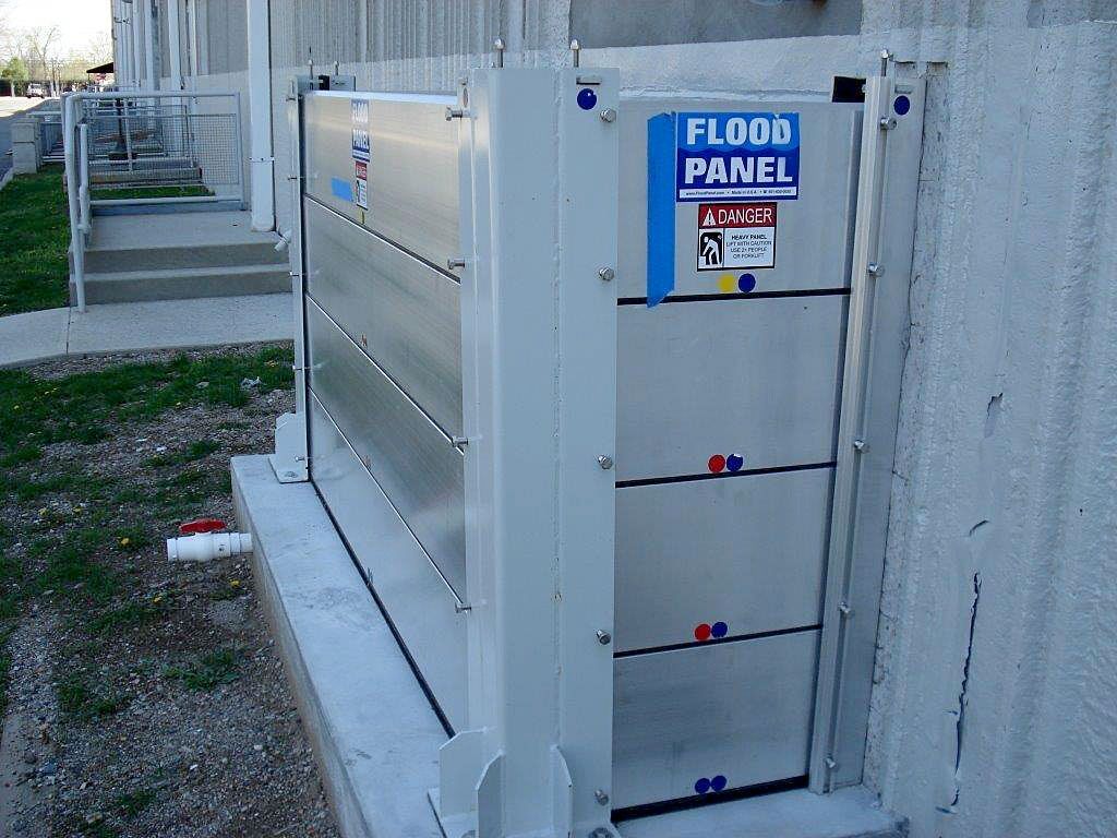 A flood panel is attached to the side of a building