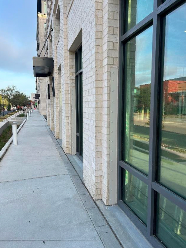 A sidewalk leading to a building with a lot of windows