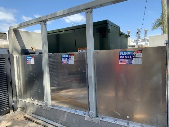 A flood panel is being installed on the side of a building.