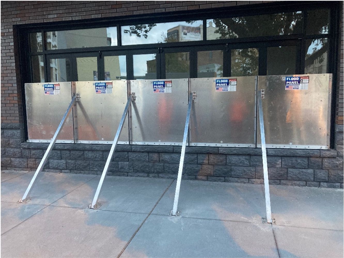 A row of metal barriers on the sidewalk in front of a building