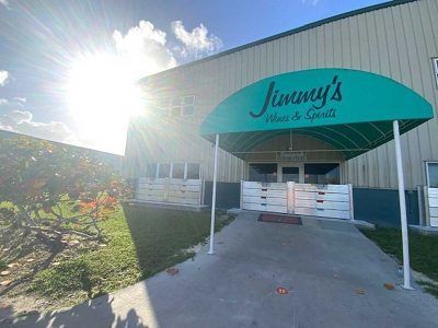 A green awning is covering the entrance to jimmy 's wine and spirits.