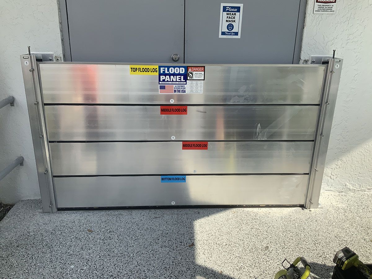 A stainless steel flood barrier is in front of a building