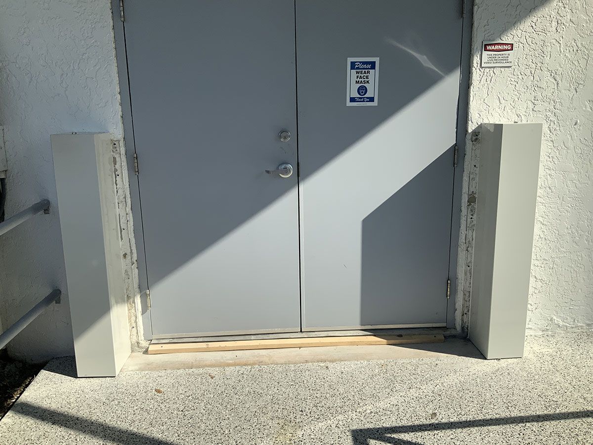 A gray door with a warning sign on it