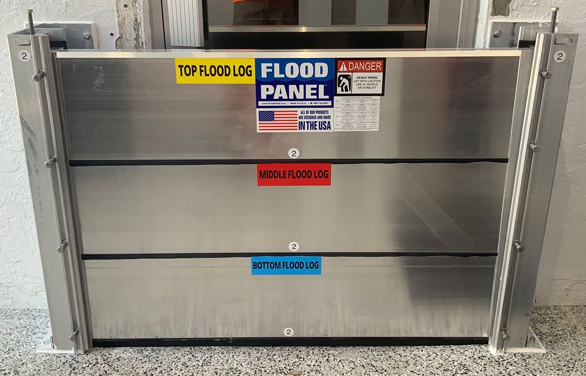 A stainless steel flood panel is sitting on a concrete floor.