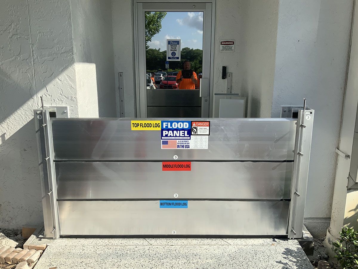 A stainless steel flood barrier is sitting in front of a door.