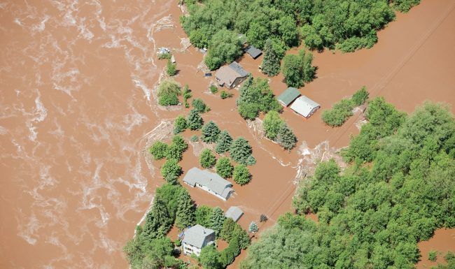 An aerial view of a flooded area with houses and trees