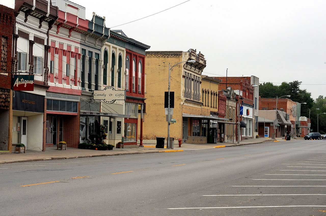 A row of buildings on the side of a street with a sign that says ' angels ' on it