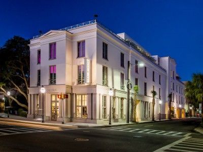 A large white building with purple windows is lit up at night.