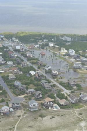 An aerial view of a flooded residential area near the ocean.