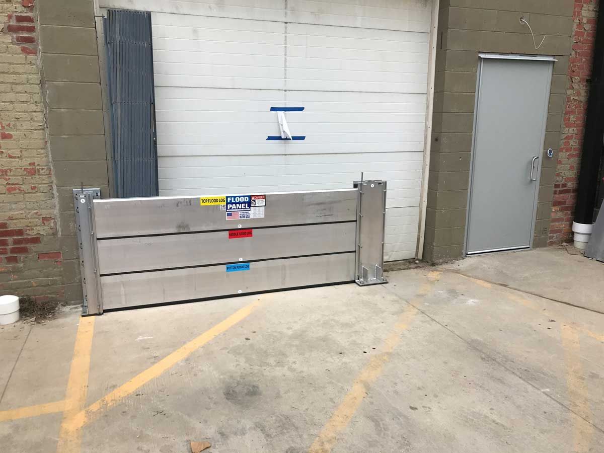 A flood barrier is sitting in front of a garage door.