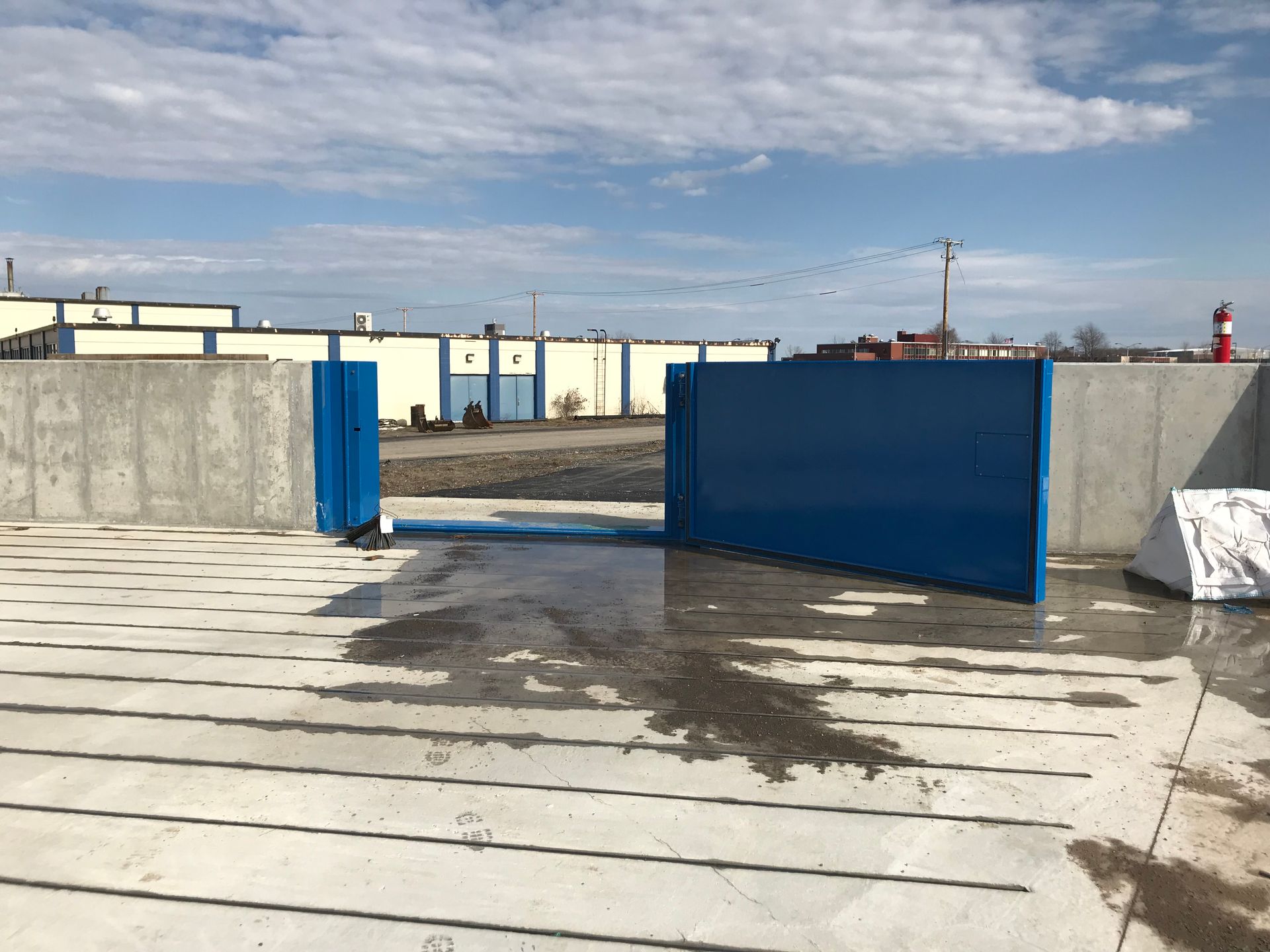 A blue wall is sitting on top of a concrete floor in front of a building.