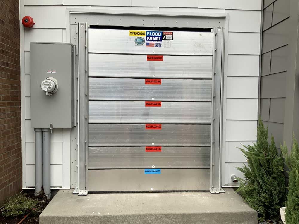 A flood barrier is installed on the side of a building.