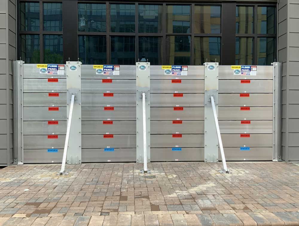 A row of aluminum flood barriers in front of a building