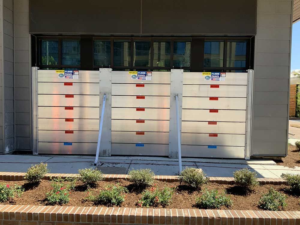 A row of flood barriers are sitting in front of a building.