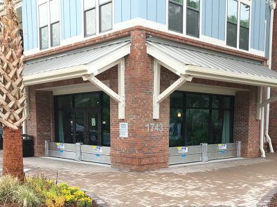 The front of a building with a brick wall and a lot of windows.