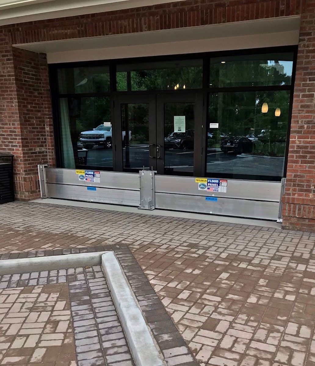 A brick building with flood barriers in front of it.