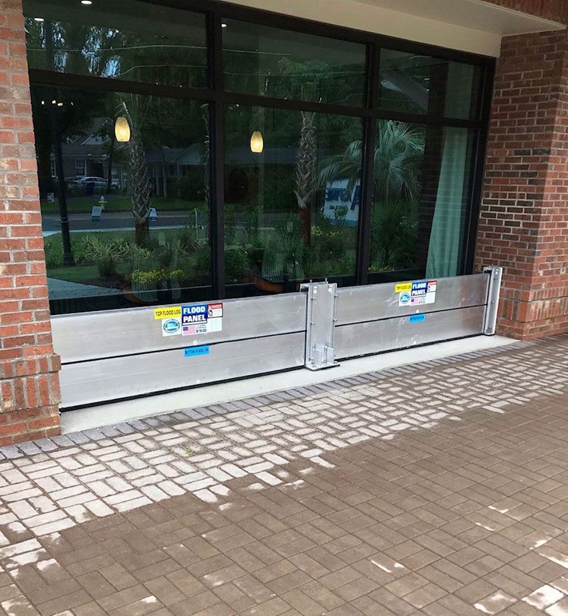 A brick building with a flood barrier in front of it.