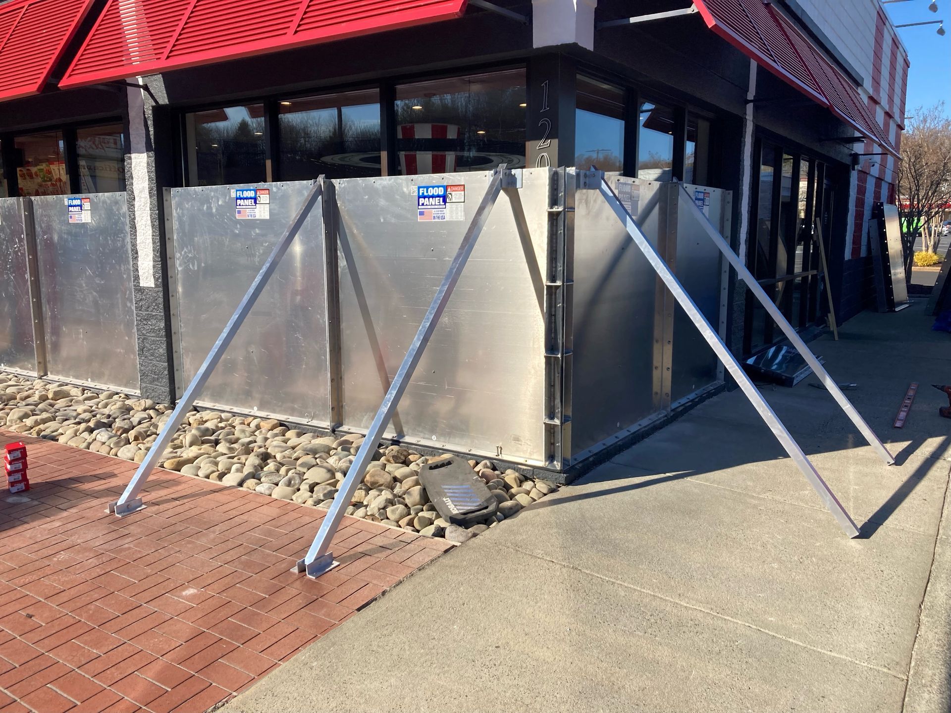 A metal barrier is being installed outside of a building.