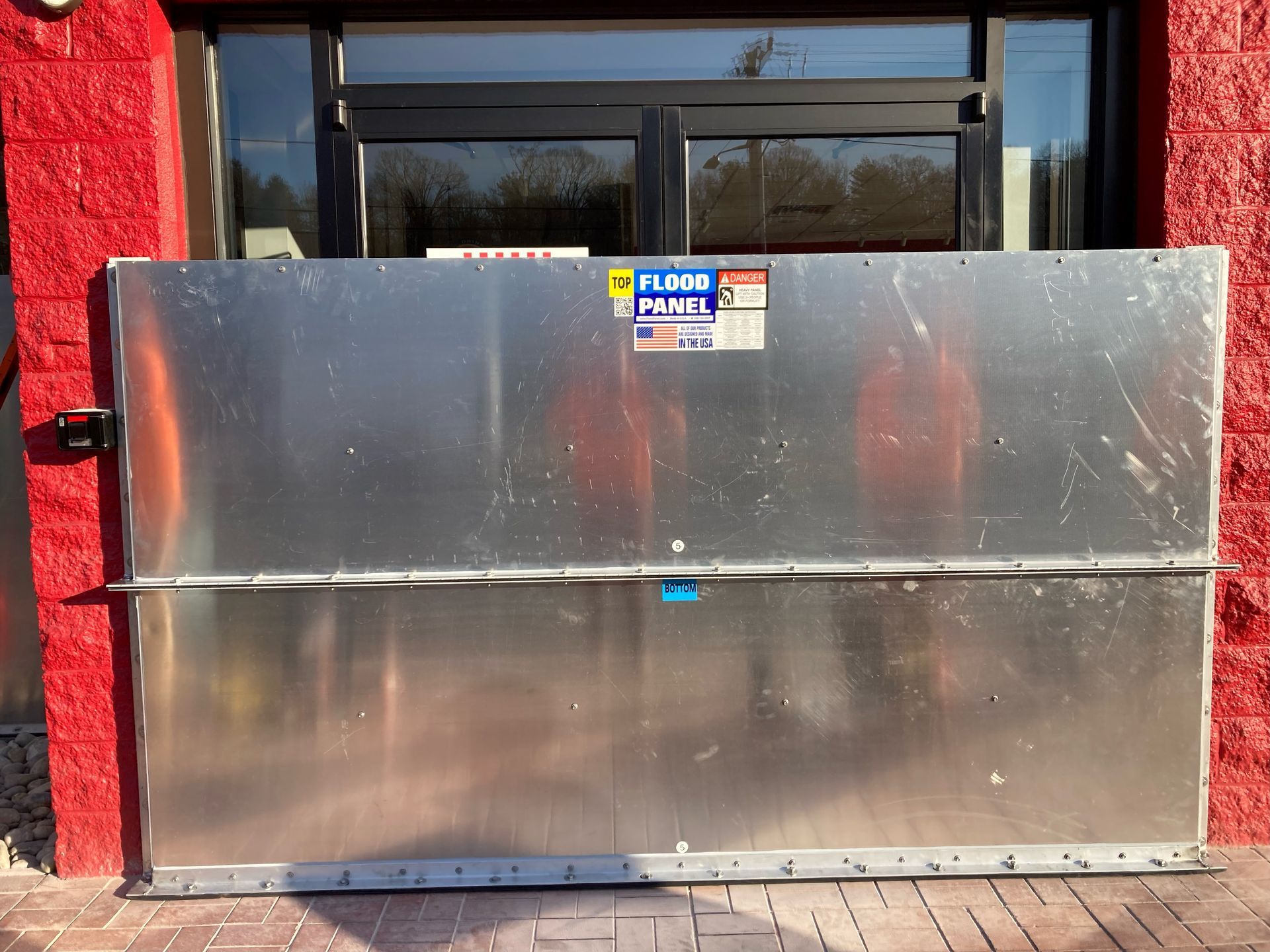 A flood barrier is in front of a red brick building