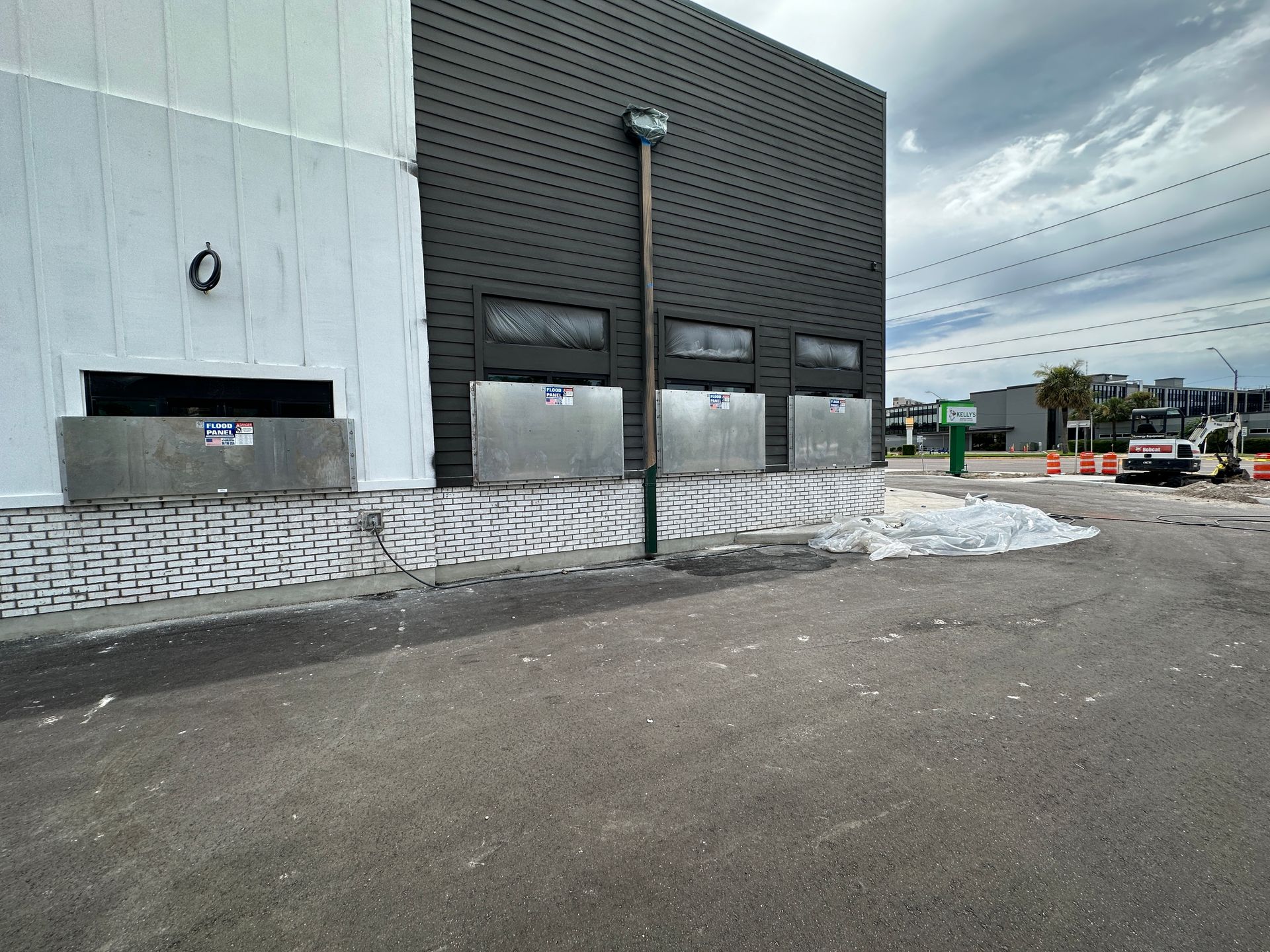 A large building with a lot of windows is being painted black and white.