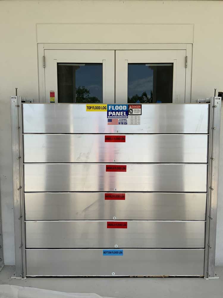 A stainless steel flood barrier is in front of a door