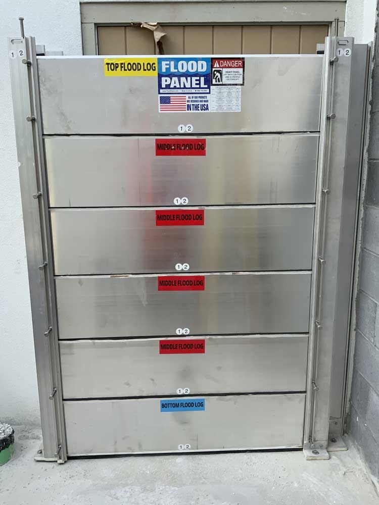 A stainless steel flood panel with a warning sign on it
