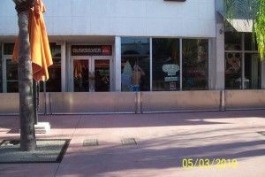A picture of a quiksilver store with an umbrella in front of it.
