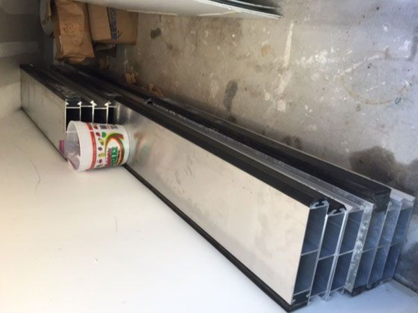A bottle of ice cream sits on a table next to a stack of metal bars.