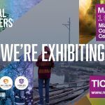 A man is standing in front of a sign that says `` we 're exhibiting ''.