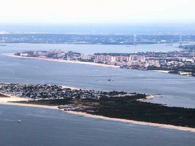 An aerial view of a large body of water with a city in the background