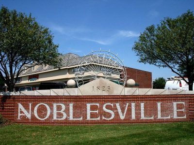 A sign that says noblesville in front of a building