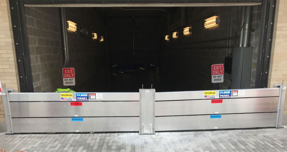 A flood barrier is sitting in front of a garage door.