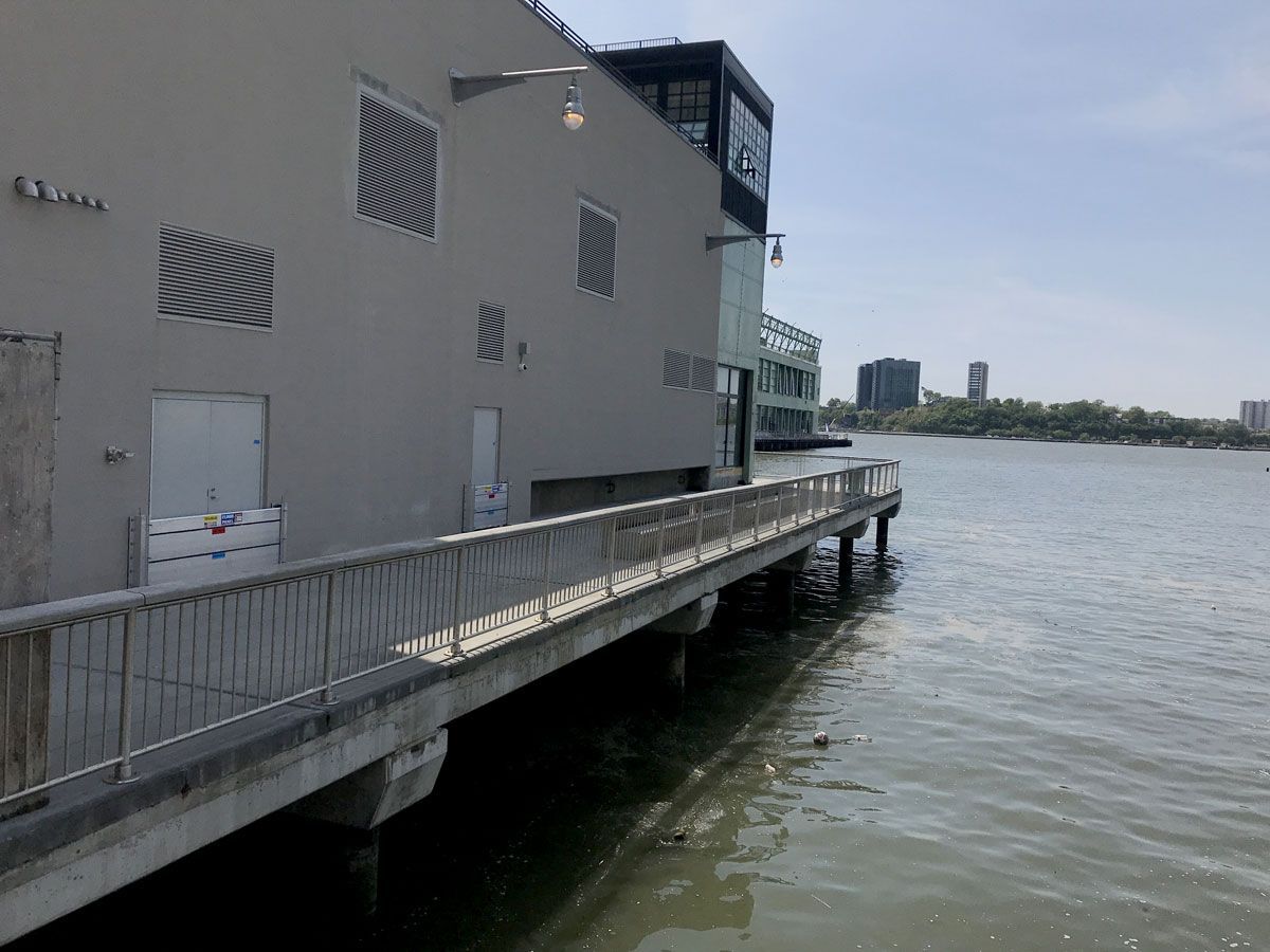A dock leading to a building next to a body of water.