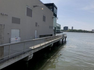 A dock leading to a building next to a body of water.