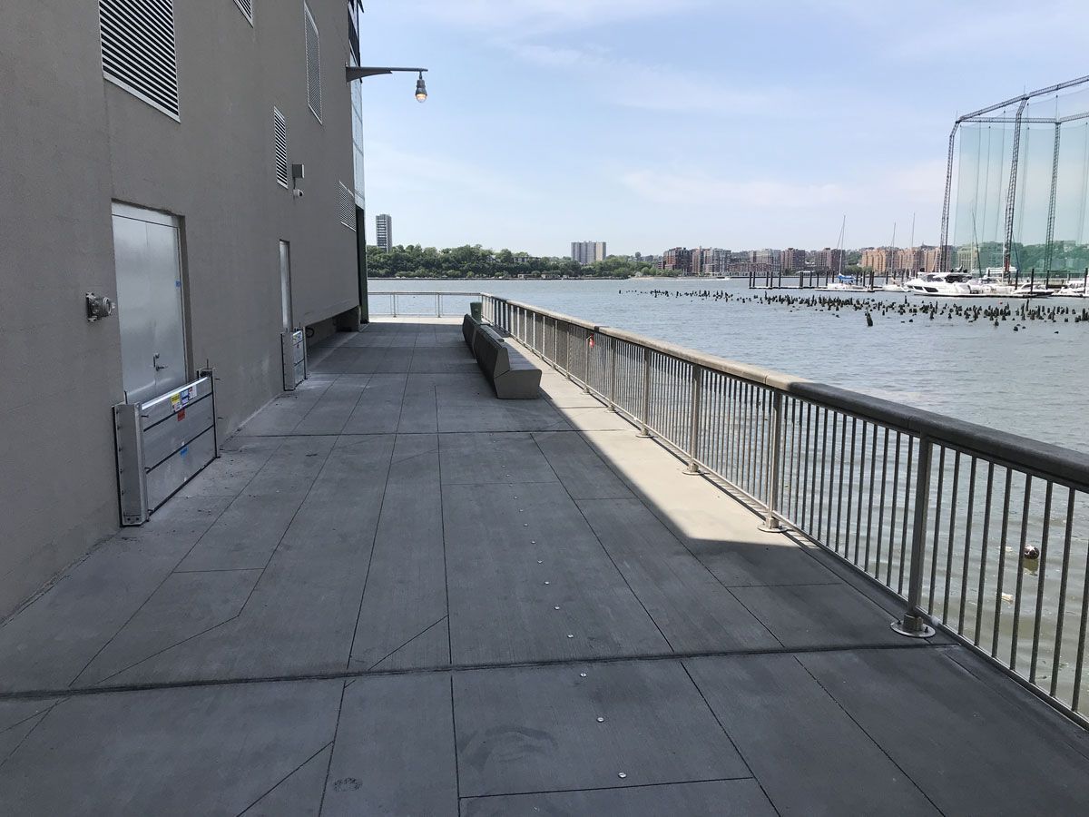 A walkway with a railing leading to a body of water.