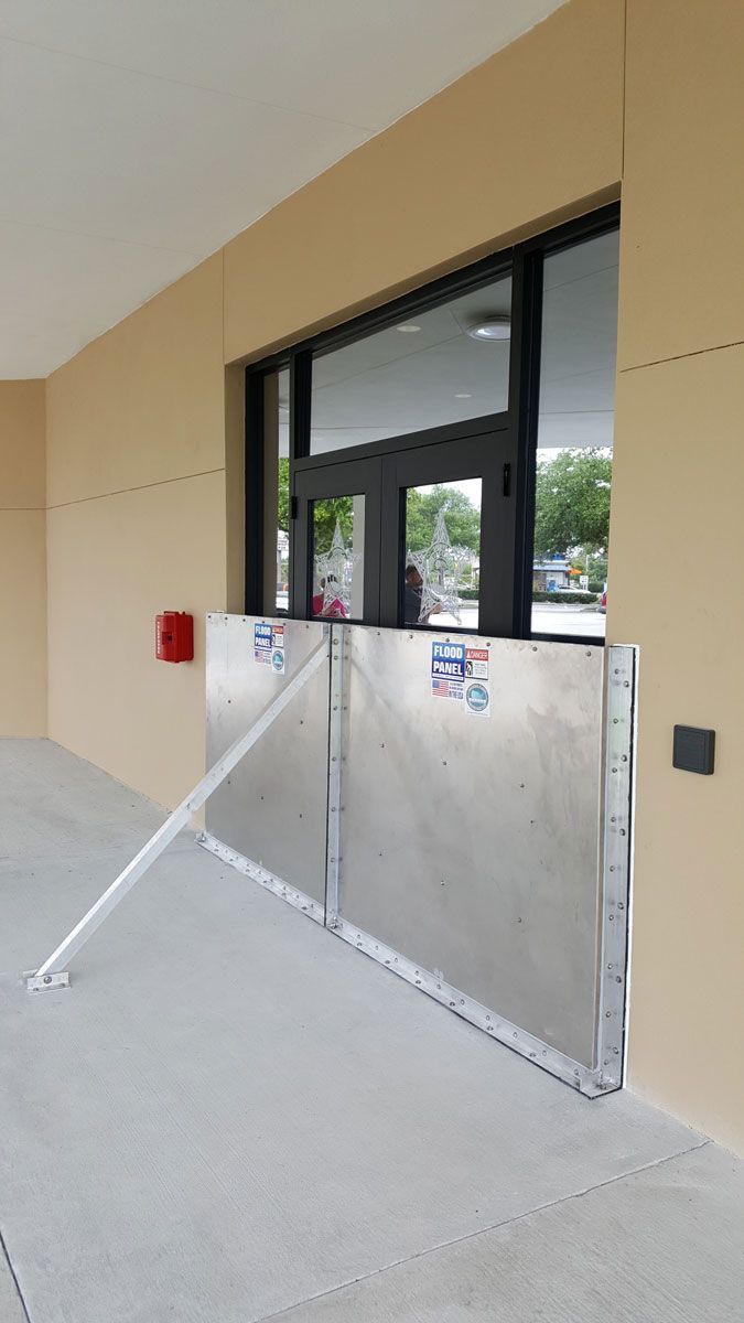 A flood barrier is sitting on the sidewalk in front of a building.