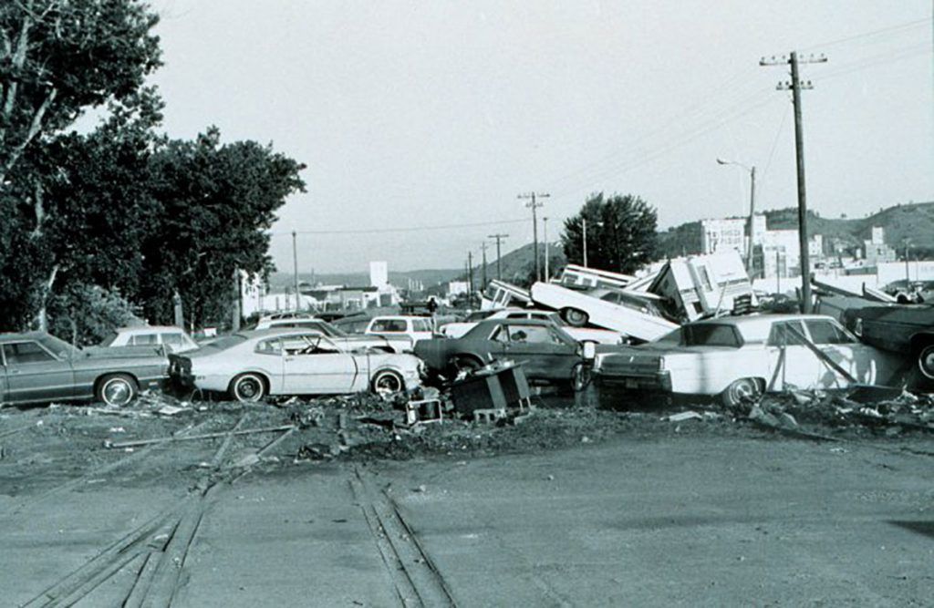 A black and white photo of a parking lot full of cars