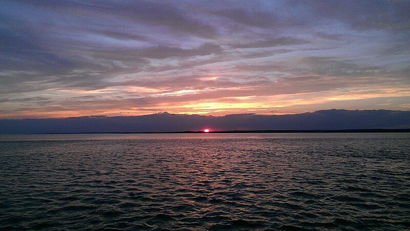 The sun is setting over a large body of water.