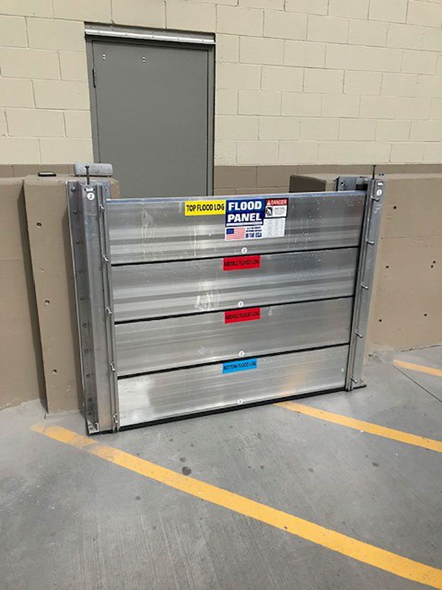 A flood barrier is sitting in a parking lot next to a door.