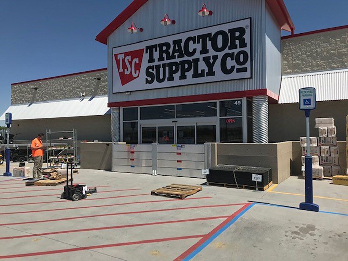 A tractor supply store with a parking lot in front of it