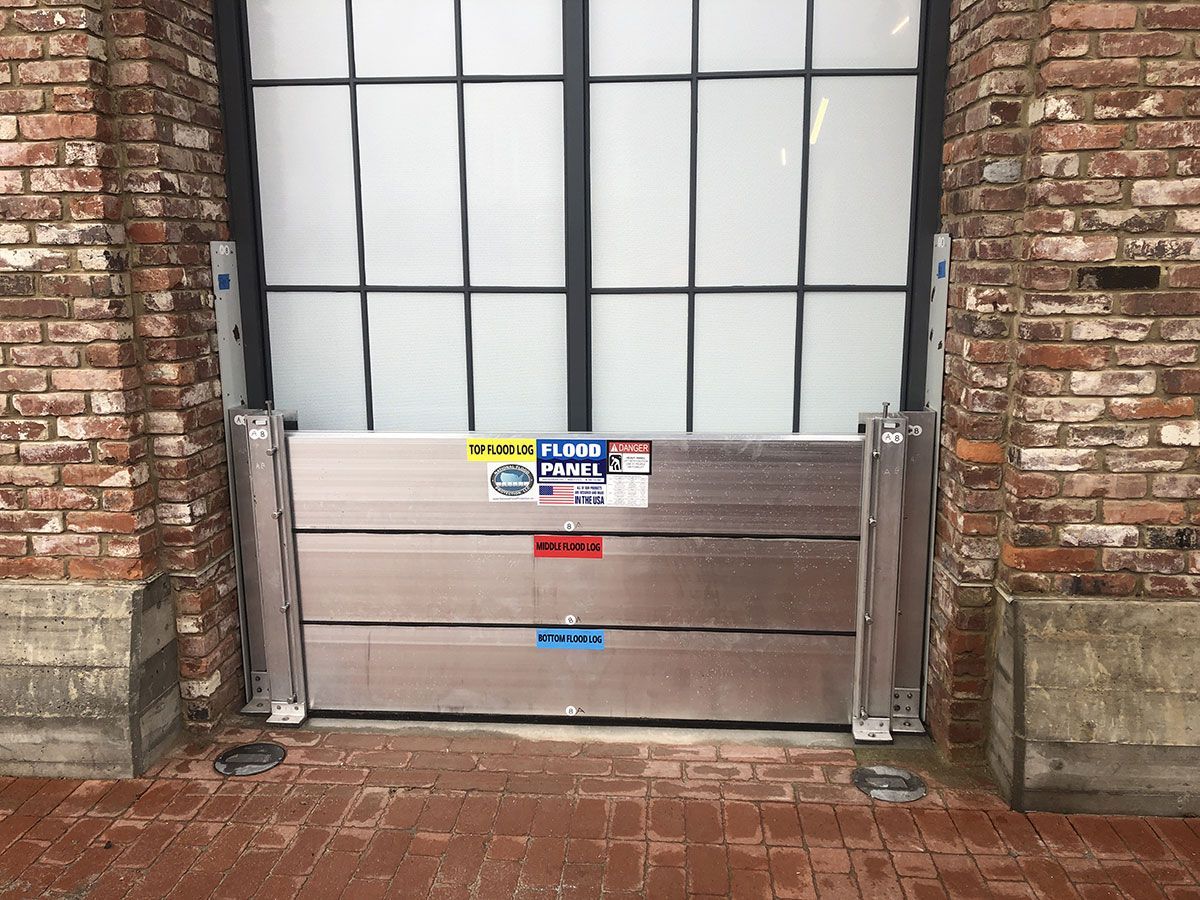 A brick wall with a flood barrier in front of it