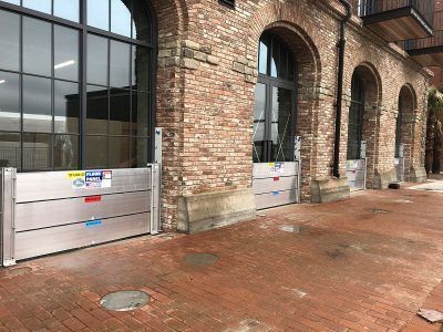 A brick building with a row of flood barriers in front of it.
