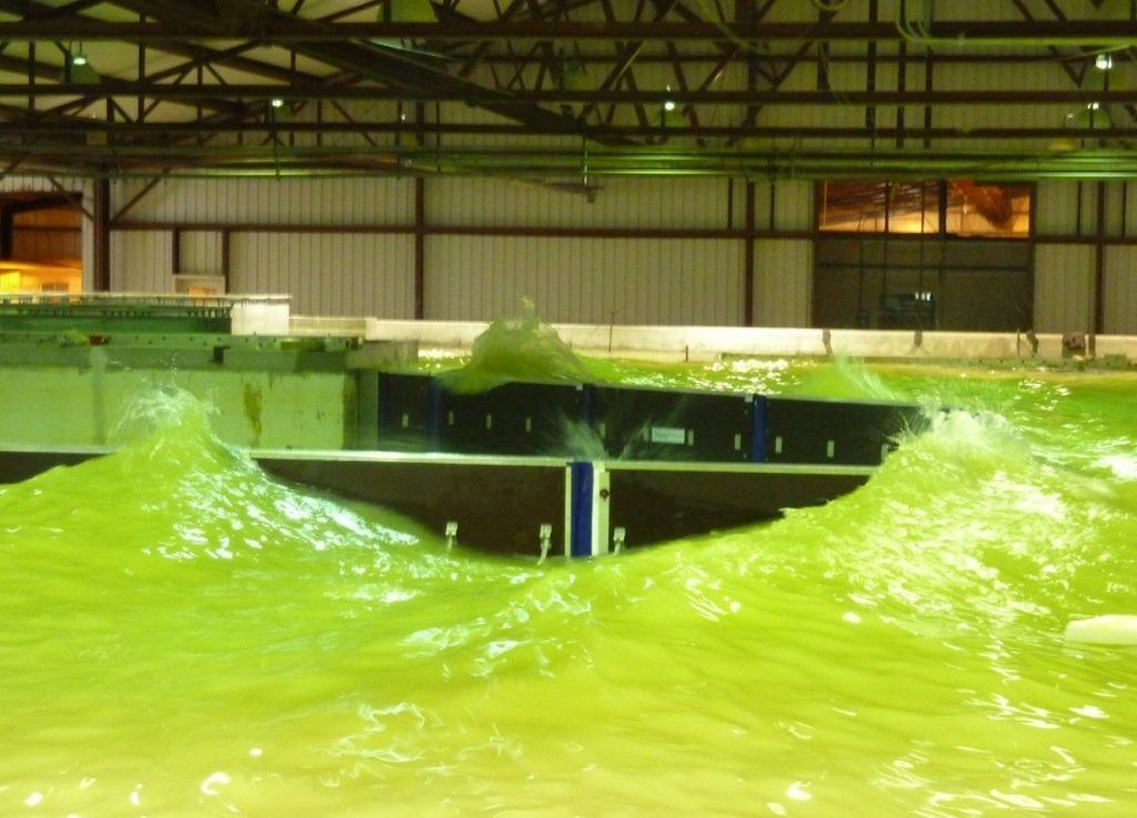 A large body of water in a building with a bridge in the background.