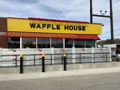 A waffle house restaurant with a yellow sign on the side of the building.
