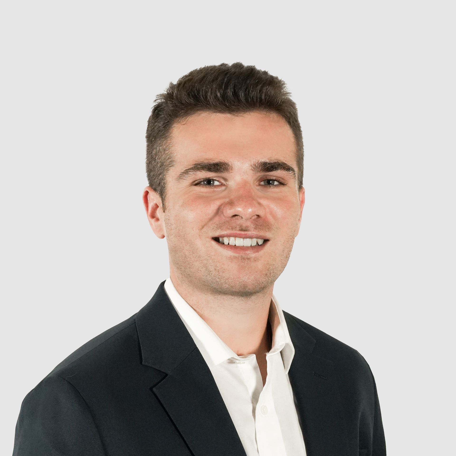 A man in a suit and white shirt is smiling for the camera