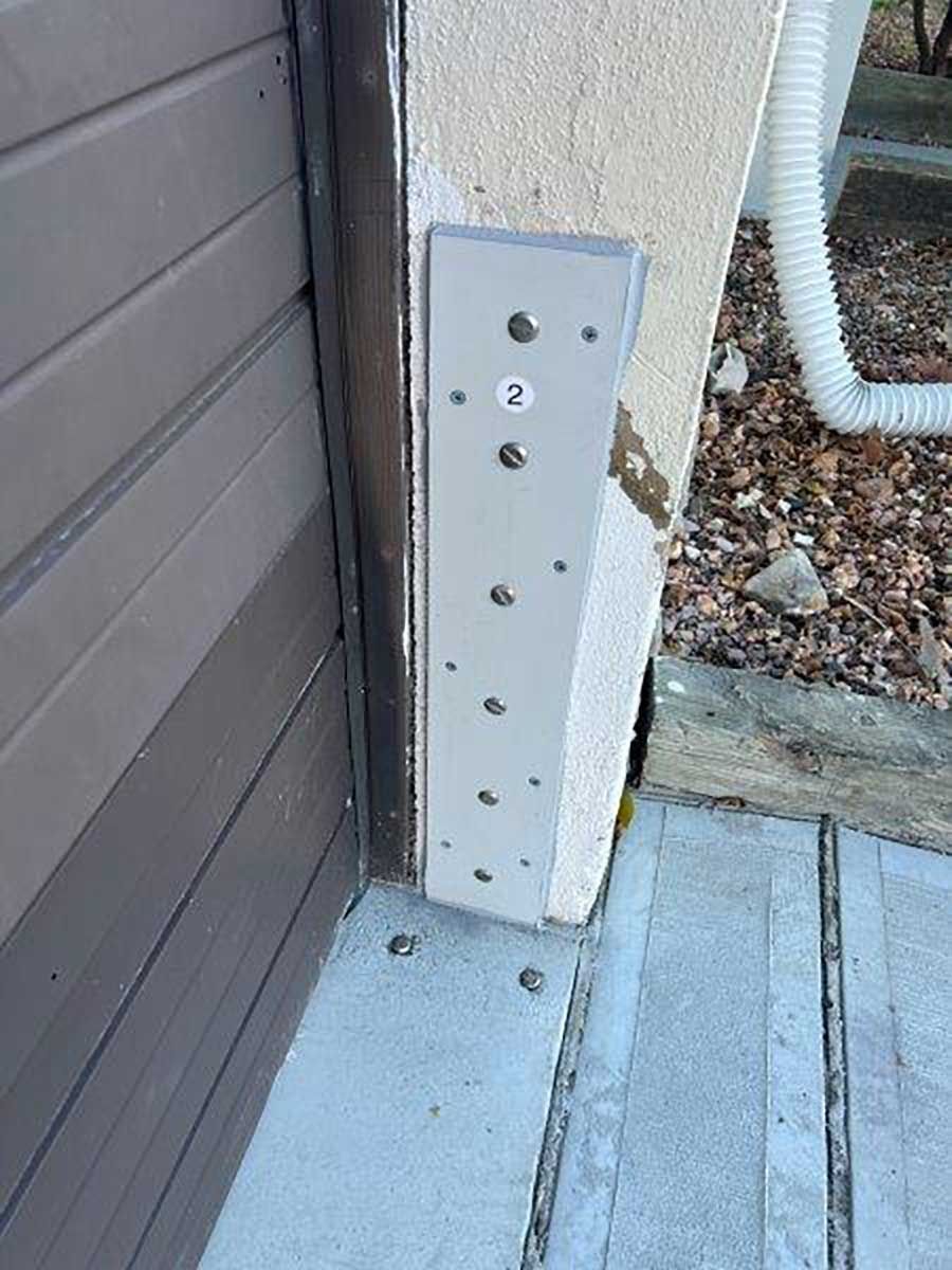 A metal bracket is attached to the side of a garage door.
